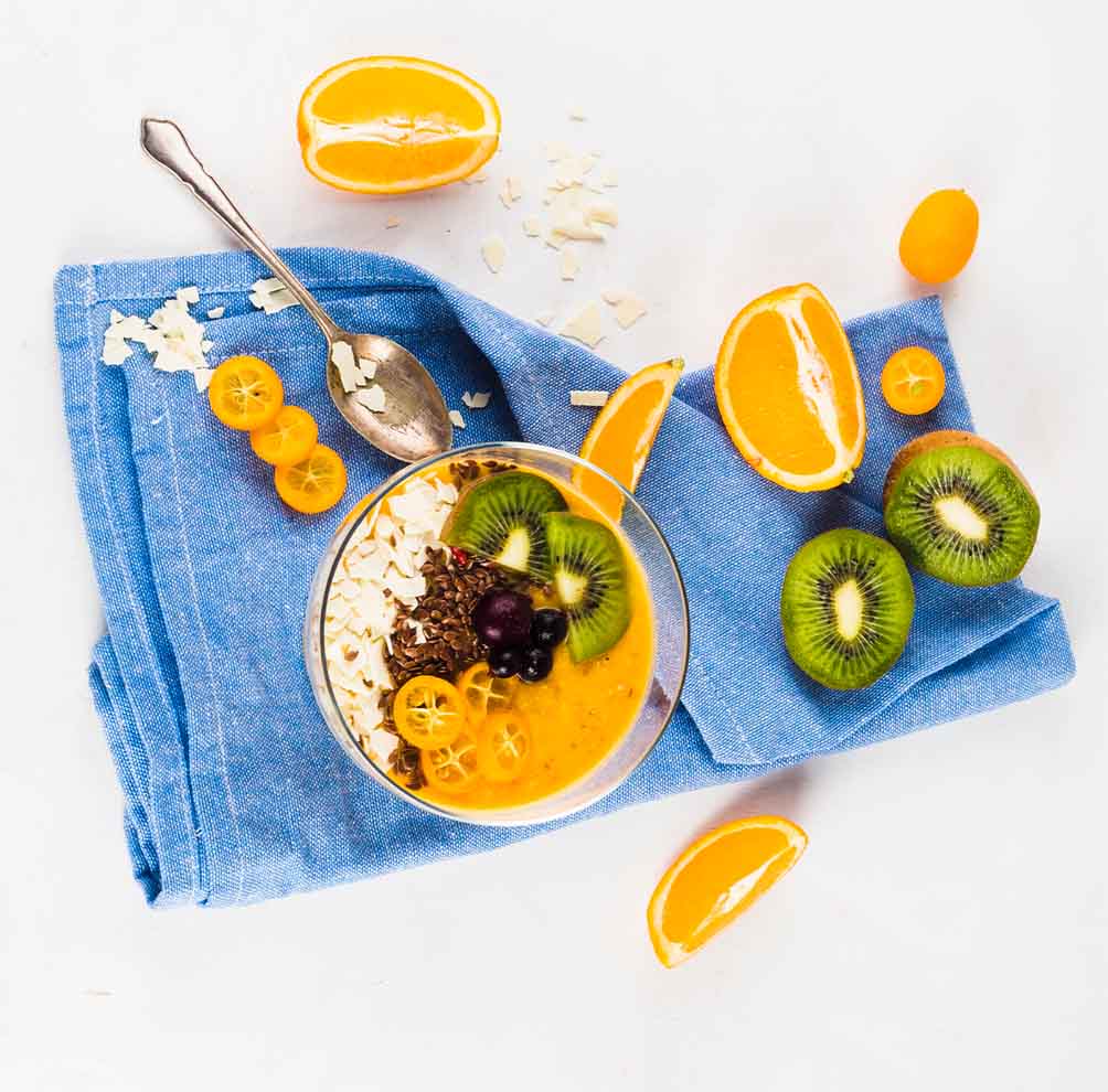 Un grupo de distintos alimentos que son ricos en vitamina C, los cuales son naranjas, kiwis, moras y cereales.