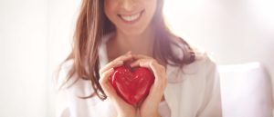 Mujer sostenido un corazón de cerámica, símbolo de su buena salud.